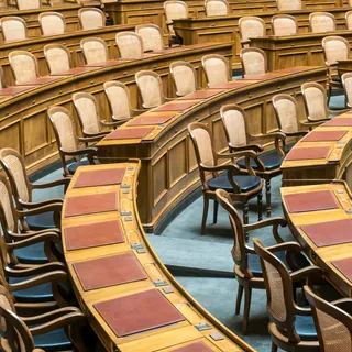 Rows of wooden chairs in a council chamber