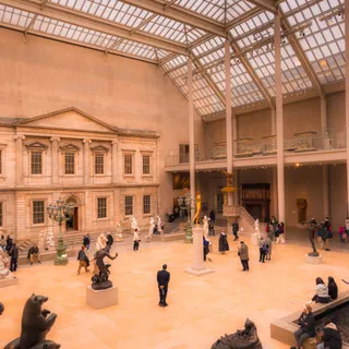 Visitors crossing a grand museum gallery