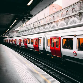 A red and white train passing an urban station