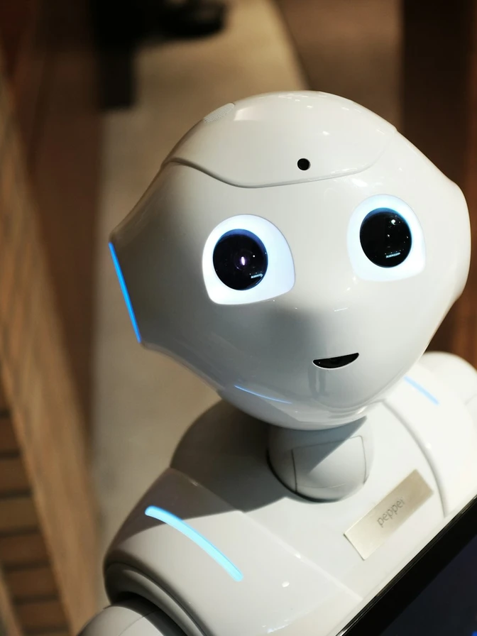 A white robot displayed against a warm wall